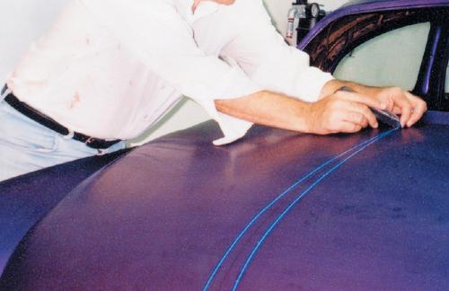 Complete the design on both sides of the centerline. If the scallop continues beyond the trunk, door or hood seam, cut the edges with a razor blade. Fill in the seam with additional tape so the paint line will continue with a perfect, unbroken appearance. 